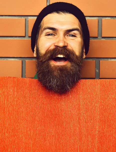 Bearded brutal caucasian hipster with red paper sheet - Photo, image
