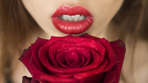 Close-up shot of sexy woman lips with red lipstick and beautiful red rose - Fotoğraf, Görsel