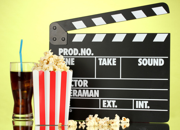 Movie clapperboard, cola and popcorn on background - Фото, изображение