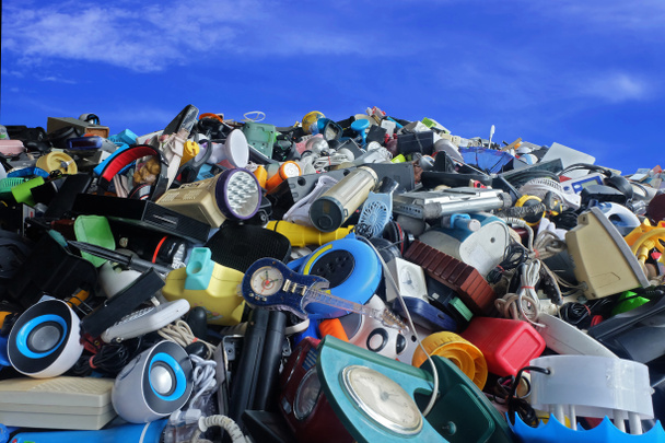 Куча использованных электронных и бытовых отходов Отдел отходов сломан или поврежден с голубым небом и облаками фона, для повторного использования и переработки концепции природы
 - Фото, изображение