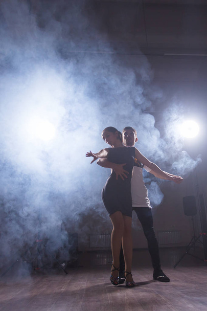 Umiejętne tancerzy w ciemnym pomieszczeniu koncert światło i dymu. Zmysłowy para wykonywanie artystycznych i emocjonalne tańca współczesnego - Zdjęcie, obraz