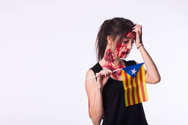 The victim woman holds the flag of Catalonia on white background with copyspace. Protest against terrorism. - Photo, Image