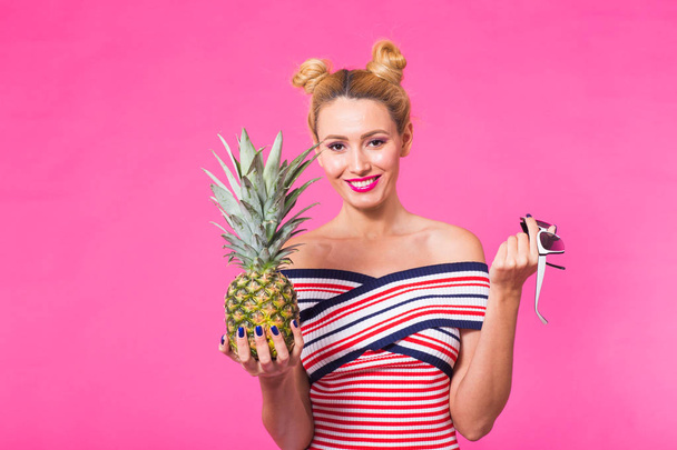 Portrait of funny woman and pineapple over pink background with copyspace. - Photo, Image