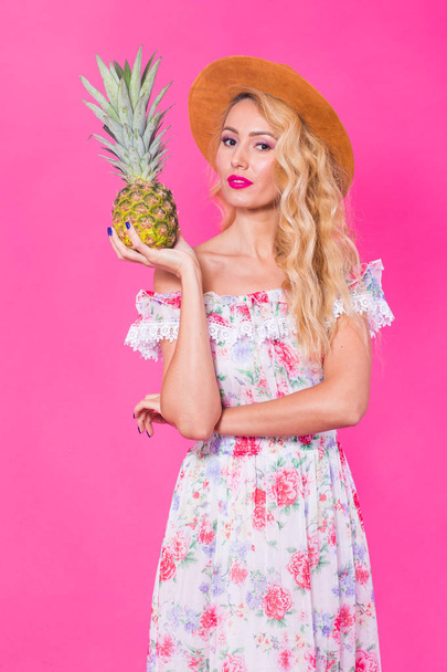 Portret van gelukkige vrouw en ananas op roze achtergrond. Zomer, voeding en gezonde levensstijl concept - Foto, afbeelding