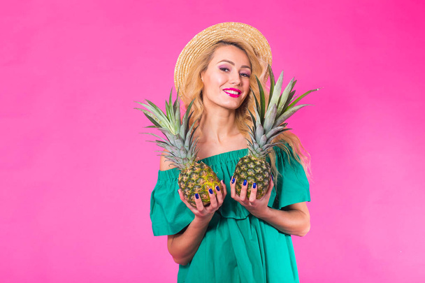 Szczęśliwa młoda kobieta trzyma ananasa na różowym tle. Koncepcja lato, dieta i święta - Zdjęcie, obraz