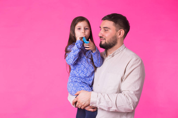 Happy father with his baby daughter on pink background - Photo, Image