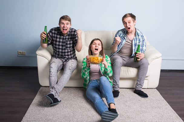 Happy friends or football fans watching soccer on tv and celebrating victory. Friendship, sports and entertainment concept - 写真・画像