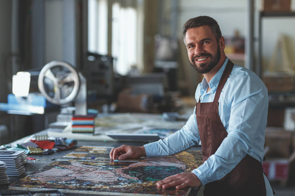 Smiling mature man at work in studio - Φωτογραφία, εικόνα
