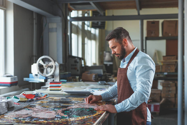 Hombre maduro con un mosaico en el taller - Foto, Imagen