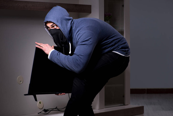 Ladrón ladrón robando tv de casa de apartamento - Foto, Imagen