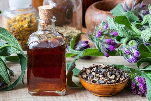Comfrey tincture with fresh symphytum officinale plant and dried root - Foto, Imagem