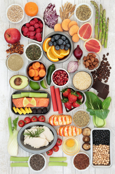 Diet food sampler with herbs used as appetite suppressants, seafood, chicken, fruit, vegetables, nuts, seeds, grains and legumes. Superfoods high in omega 3, antioxidants, anthocyanins, fiber and vitamins. Top view. - Photo, Image