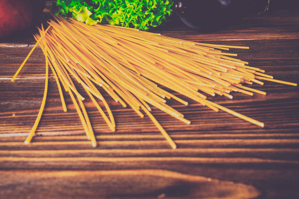 Spaghetti and vegetables on a wooden background - Φωτογραφία, εικόνα
