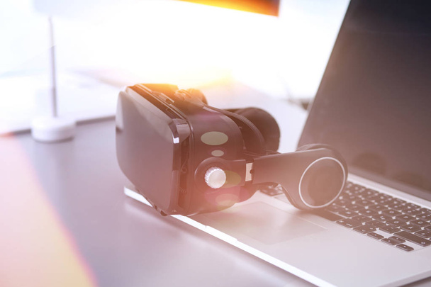 Virtual reality goggles on desk with laptop. business. 3d technology - 写真・画像