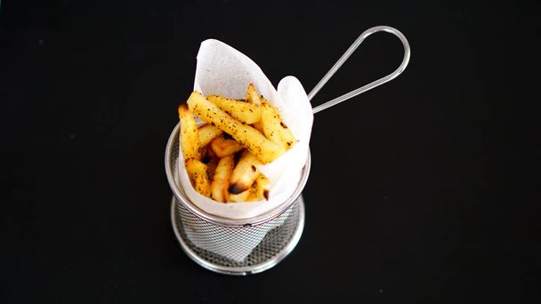 fried potatoes on black table - Photo, image