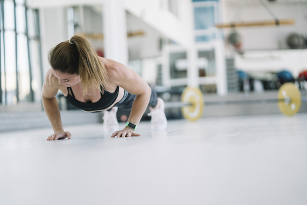 Γυναίκα που εκτελεί κινητικότητα ασκήσεις στο γυμναστήριο - Φωτογραφία, εικόνα