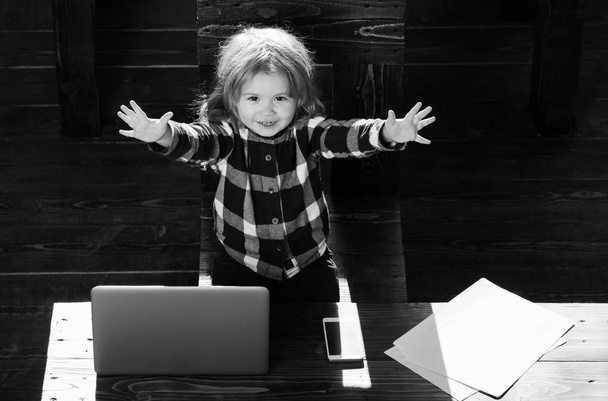 happy boy kid in office with laptop, phone, paper sheet - Фото, изображение