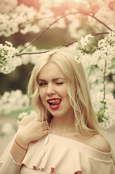 Sensual woman in cherry bloom listen music. Music and relax, spring. - Zdjęcie, obraz