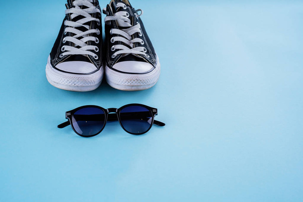 Sneakers en glazen op een blauwe achtergrond - Foto, afbeelding