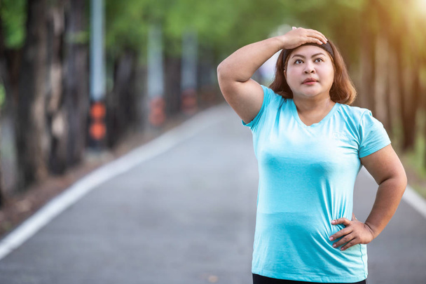 Exercise and healthy concept : Fat woman feeling tired while running in the park - Foto, afbeelding