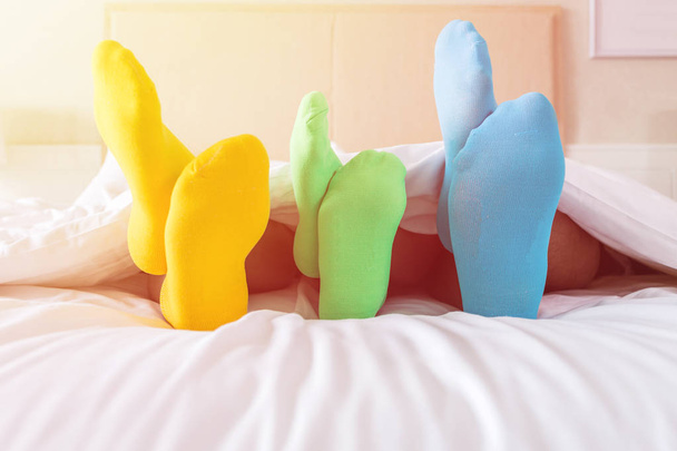 Close up foots of family with color sock on the bed - Φωτογραφία, εικόνα