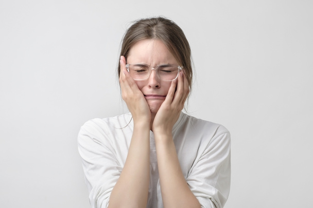 Vrouw in de moderne bril die betrekking hebben op oren en schreeuwen. Ze is wanhopig vanwege probleem op school of werk - Foto, afbeelding