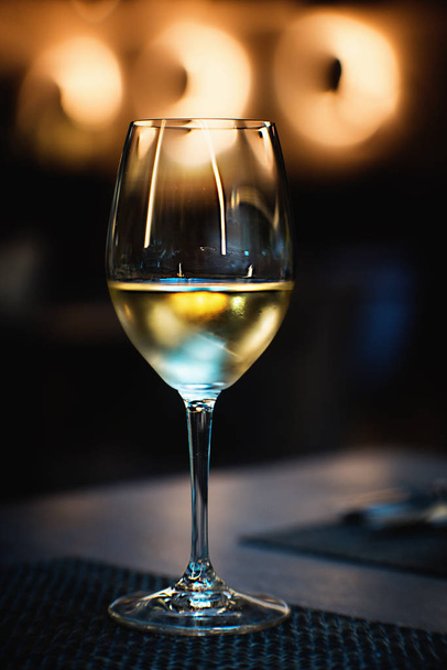 Wineglass with a white wine on a table. Close up. - Foto, Bild