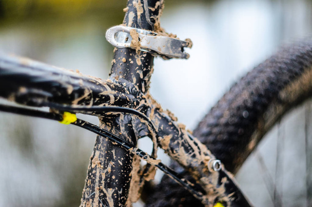 A bicycle in the mud. Elements of a mountain bike frame covered with mud after riding in bad weather - Photo, image