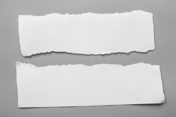 Valkoinen revitty paperi harmaalla pohjalla. keräyspaperi repeämä - Valokuva, kuva