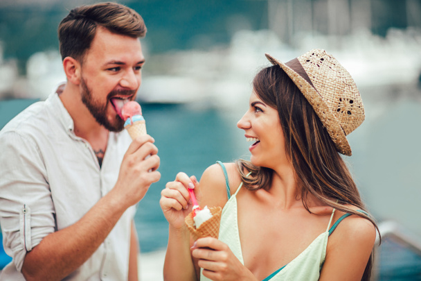 Couple having date and eating ice cream on vacation at seaside. - Photo, Image