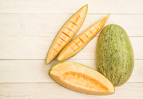 organic melon slices on white wooden background - Foto, Imagem