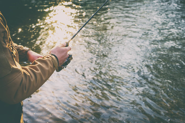 Pescatore cattura una trota su un fiume di montagna
 - Foto, immagini
