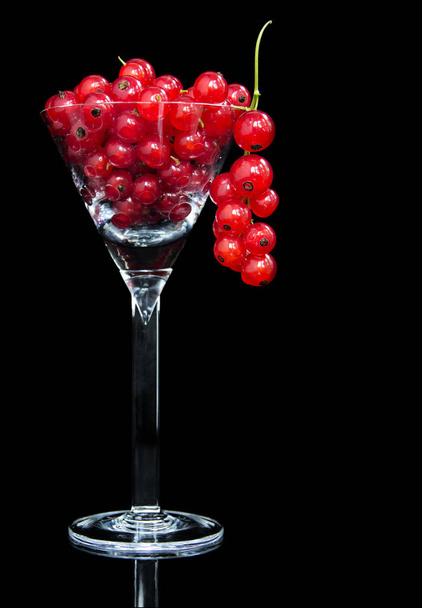 Red currants in cocktail glass against black background  - Фото, зображення