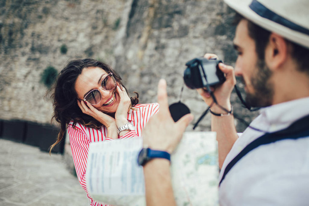 Tourist couple enjoying sightseeing and exploring city and making photo using camera - 写真・画像