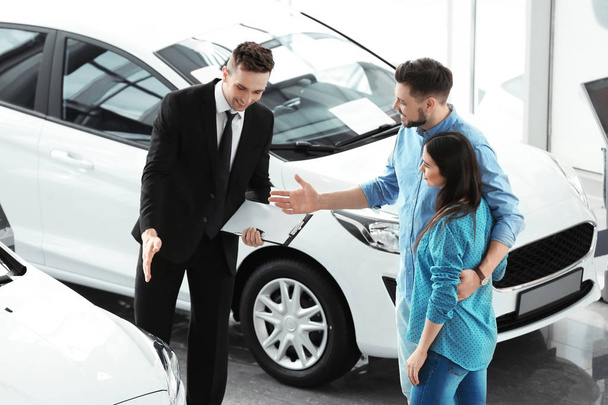 Young couple buying new car in salon - Photo, image