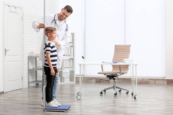 Doctor measuring little boy's height in hospital - Foto, imagen
