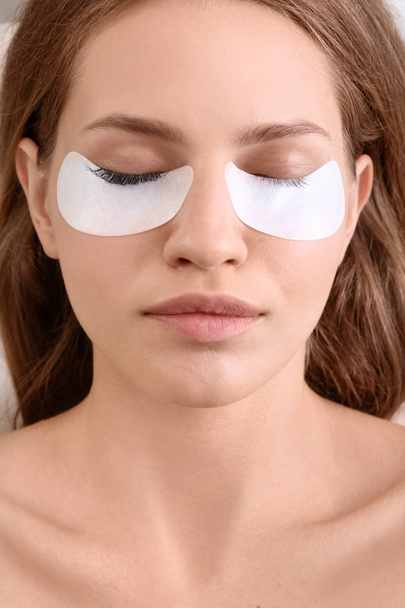 Young woman undergoing eyelash extensions procedure, closeup - 写真・画像