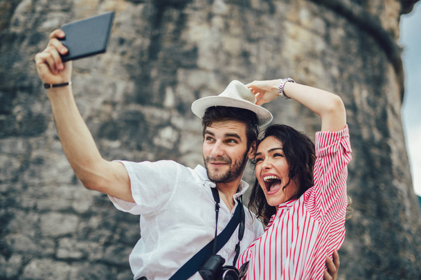 Turistické pár těší vyhlídkové a prohlídkou města a dělat fotografie pomocí fotoaparátu - Fotografie, Obrázek