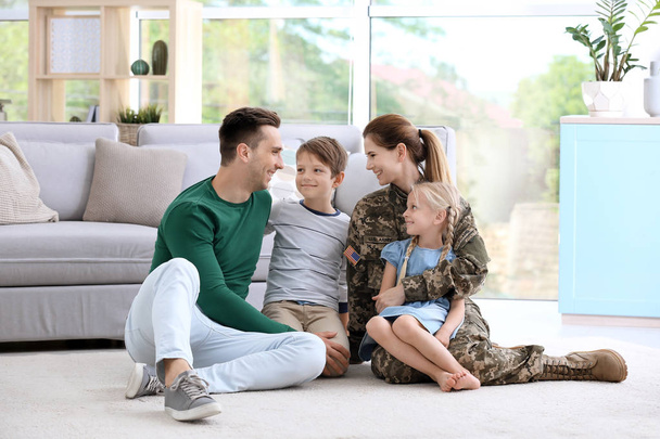 Woman in military uniform with her family at home - Foto, Imagen