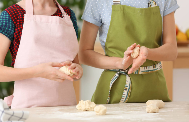 Mother and her daughter preparing dough at table, closeup - Foto, Imagem