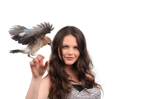 Portrait of smiling girl with bird on the hand - 写真・画像