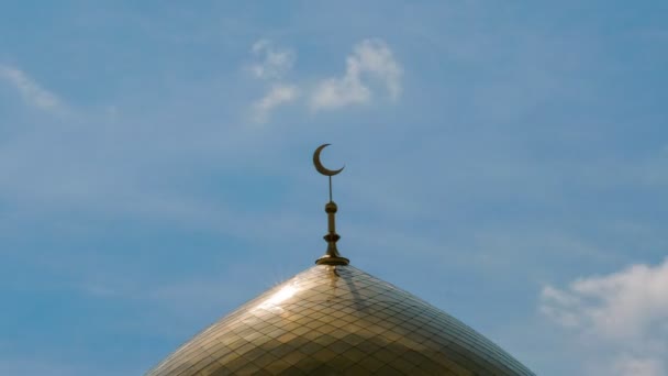 Auringonvalo moskeijan minareetissa islamilaisen uskonnon symbolilla kultainen puolikuu kehyksen keskellä sinistä taivasta vasten pilvillä. Aikaväli
. - Materiaali, video