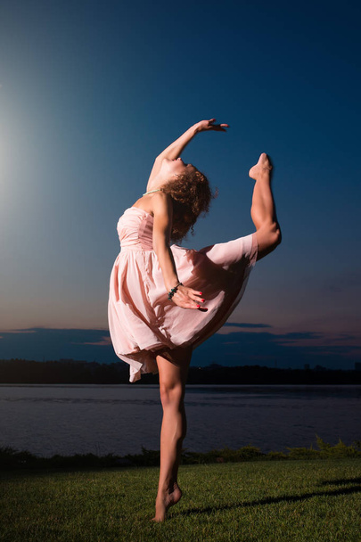 Flexible ballerina in pink dress dancing, magic mystery portrait - Foto, Imagen