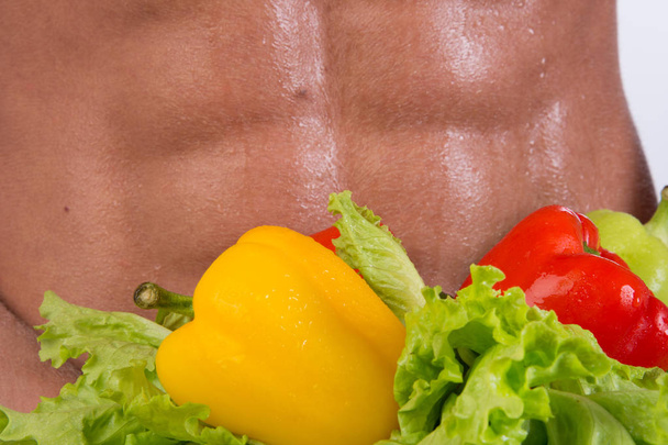 Sport and diet. Attractive man with muscular body. Athletic guy and vegetables. Healthy eating - Foto, immagini
