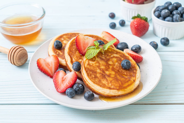 souffle pancake with fresh blueberries, fresh strawberries and honey - Valokuva, kuva