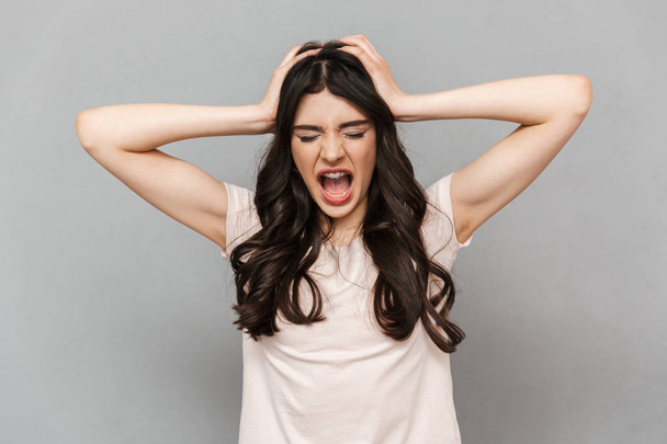Photo of emotional young lady standing isolated over grey background wall screaming. - 写真・画像