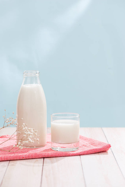 Productos lácteos. Botella con leche y vaso de leche sobre mesa de madera
 - Foto, imagen