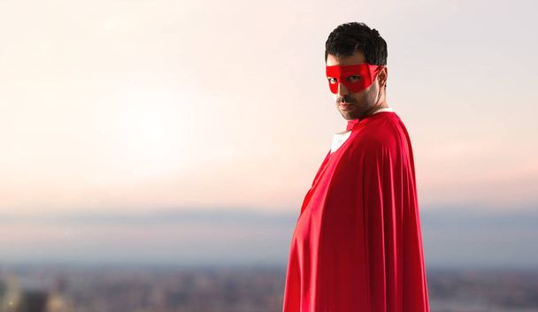 Superhero człowiek pelerynie maski i czerwony na tle zachodu słońca - Zdjęcie, obraz