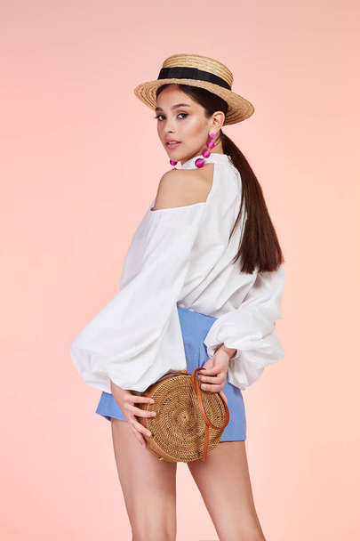 Brunette sexy elegant woman natural beauty fashion style clothes summer blouse short lady romantic meeting date party style glamour model trend hair makeup accessory bag straw hat jewelry earring. - Zdjęcie, obraz