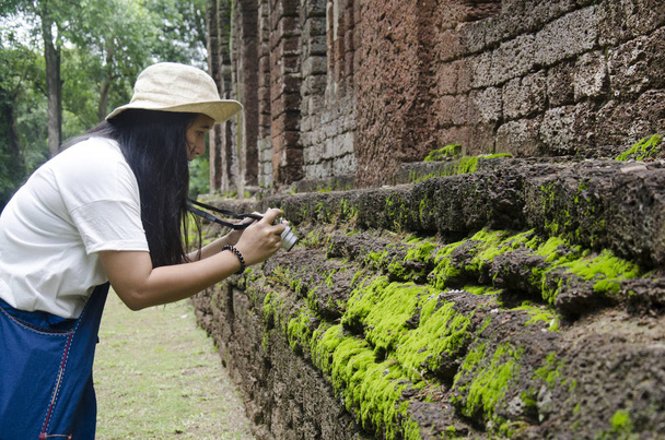 Thaise vrouw reizigers wandelen van bezoek en reizen foto nemen in oud gebouw en ruïnes van Kamphaeng Phet Historical Park is een archeologische site en het Aranyik gebied in Kamphaeng Phet, Thailand - Foto, afbeelding